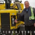 The Metrolite HLT 6150 Hybrid Light Tower with a man standing beside it