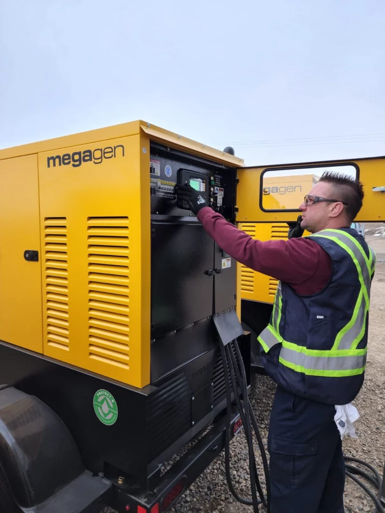 Engineer in safety gear adjusting settings on a Megagen generator at a construction site