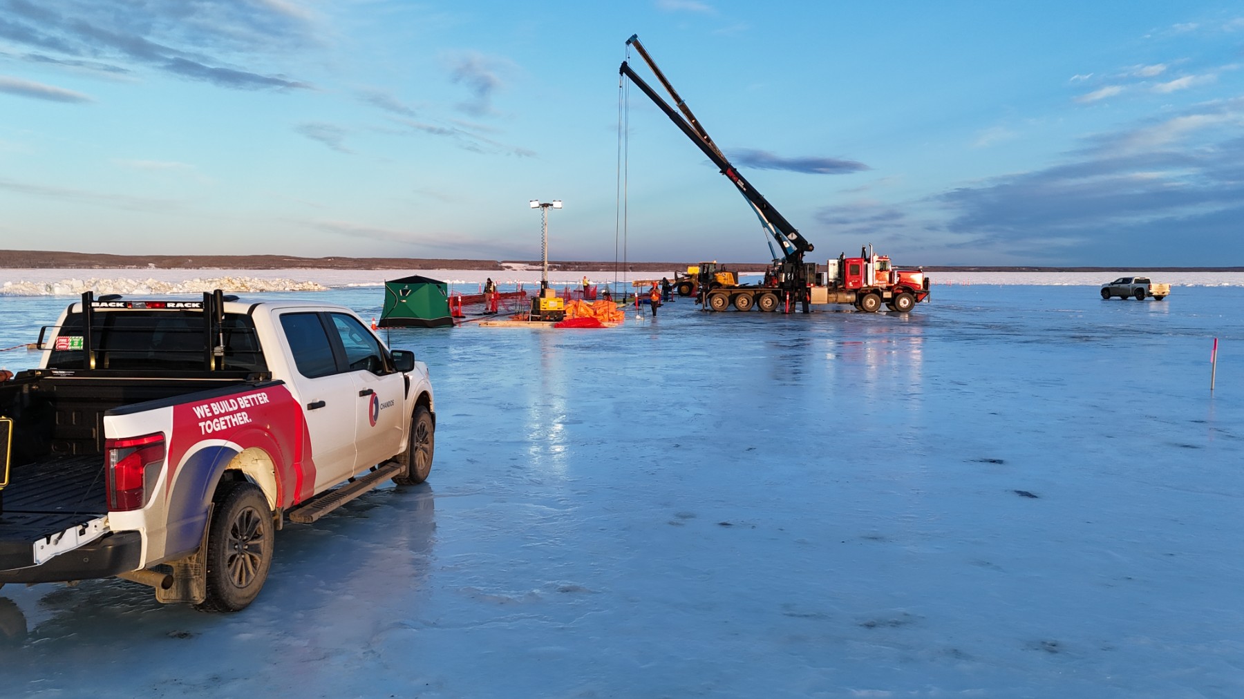 LED light tower and crews working on ice platform with heavy equipment at Frog Lake site