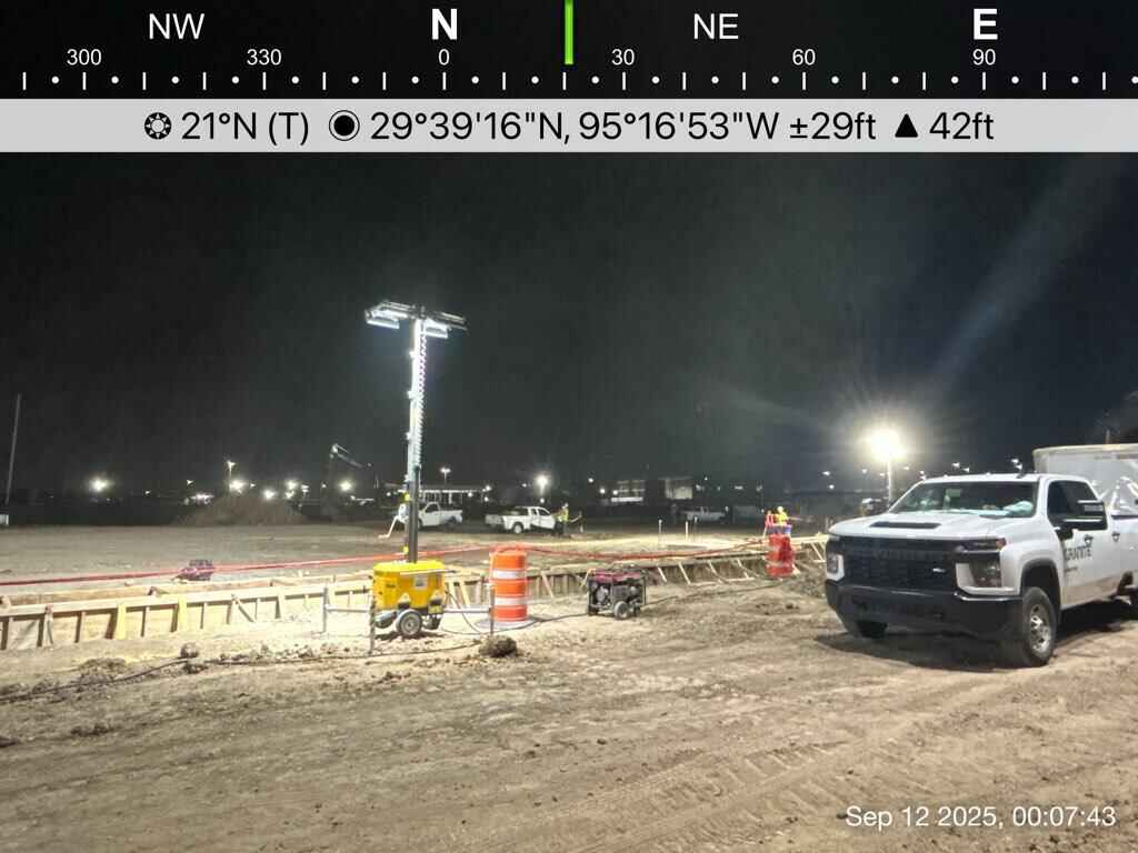 Construction crew gathered around a hybrid light tower for on-site operator training at a Houston airport project.
